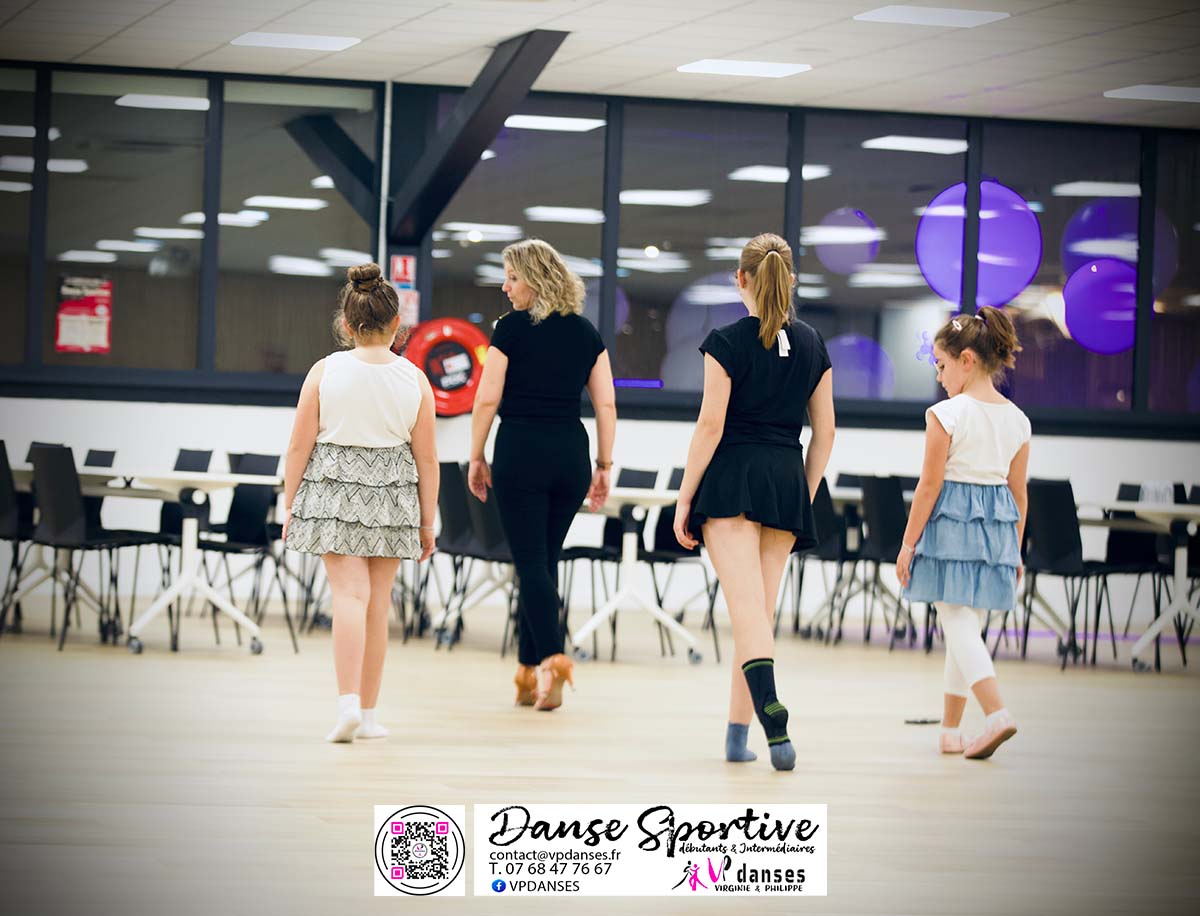 Trois enfants débutantes en danse sportive pratiquant les positions de pieds et bras ensemble